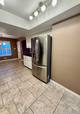a kitchen with stainless steel appliances granite countertop a refrigerator and a stove top oven