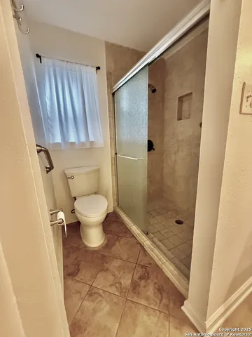a bathroom with a toilet and a shower
