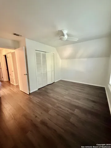 an empty room with wooden floor and window