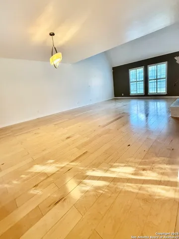 a view of empty room with wooden floor and window