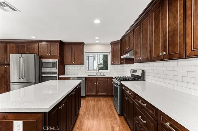 a view of kitchen with stainless steel appliances cabinets and wooden floor
