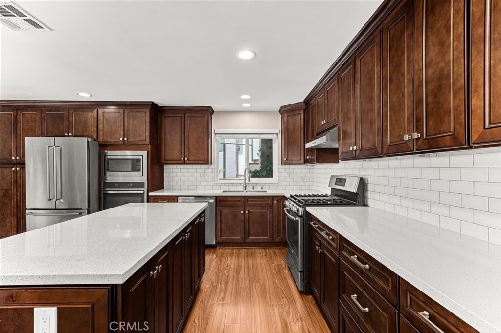 3751 Prestwick Drive Los Angeles, CA 90027 - Photo 15 of 50 a kitchen with stainless steel appliances a sink dishwasher stove refrigerator and cabinets