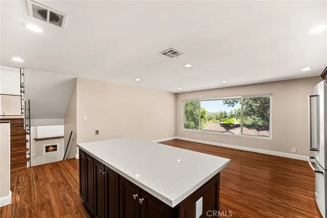 a view of a kitchen with wooden floors and stainless steel appliances