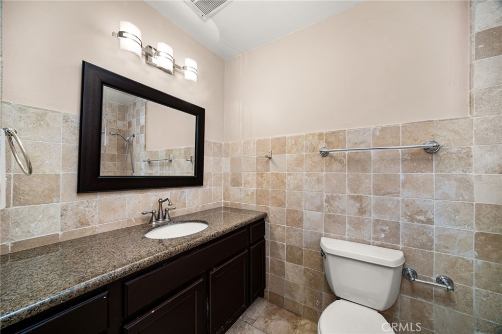 3751 Prestwick Drive Los Angeles, CA 90027 - Photo 37 of 50 a bathroom with a toilet sink double vanity and mirror