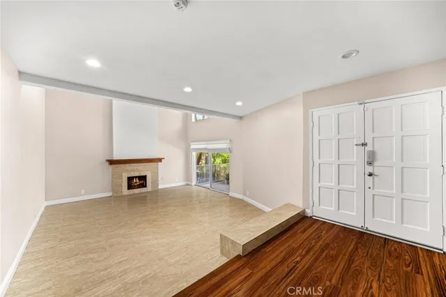 a view of an empty room with a fireplace and a window