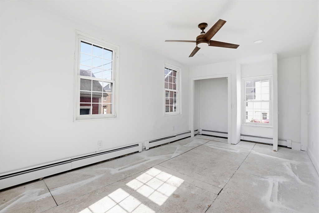 4 Townsend Street Pepperell, MA 01463 - Photo 19 of 27 an empty room with windows and ceiling fan