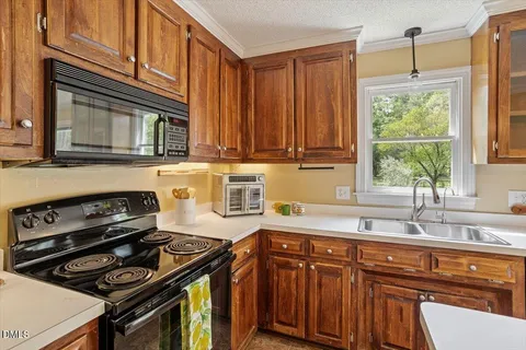 a kitchen with granite countertop a stove sink and cabinets