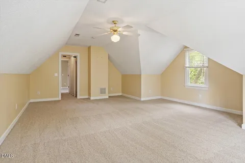 an empty room with windows and chandelier fan