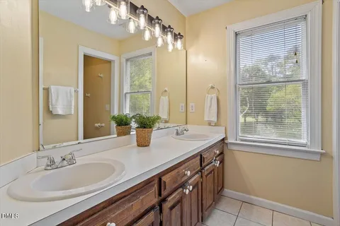 a bathroom with a granite countertop sink a large mirror and a shower