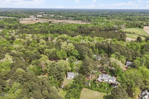 an aerial view of residential houses with outdoor space and trees