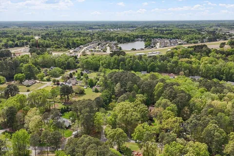 an aerial view of residential houses with outdoor space and trees