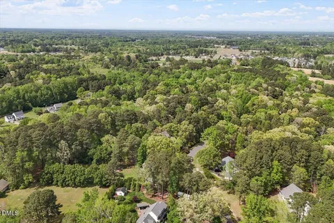 an aerial view of residential houses with outdoor space and trees