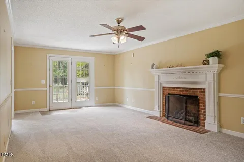a view of empty room with fireplace and fan