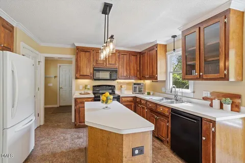 a kitchen with a sink a stove a refrigerator and cabinets