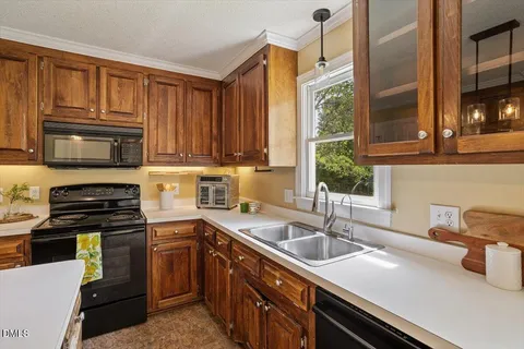 a kitchen with a sink stove top oven and microwave