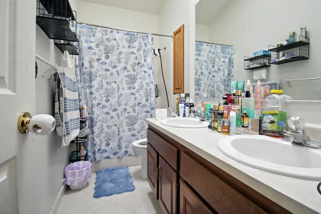 a bathroom with a sink vanity granite and a shower
