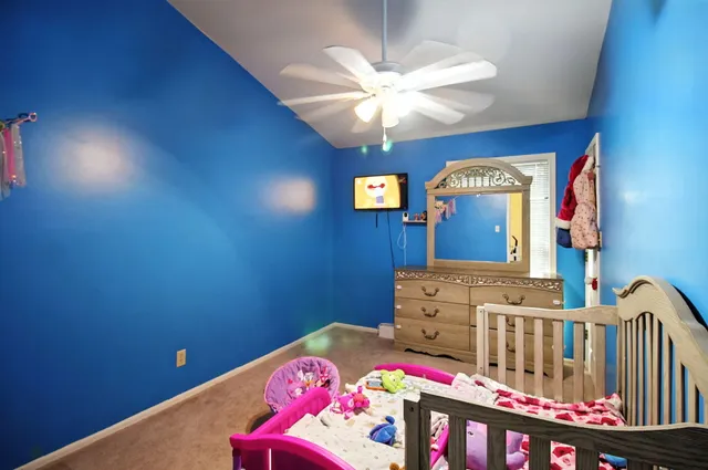 a bedroom with a bed a chandelier and dresser