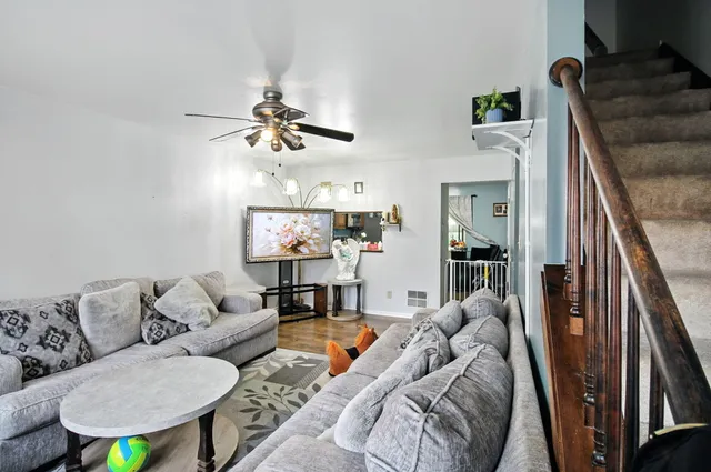 a living room with furniture ceiling fan and a rug