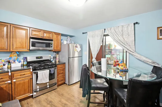 a kitchen with stainless steel appliances a stove a refrigerator and a dining table