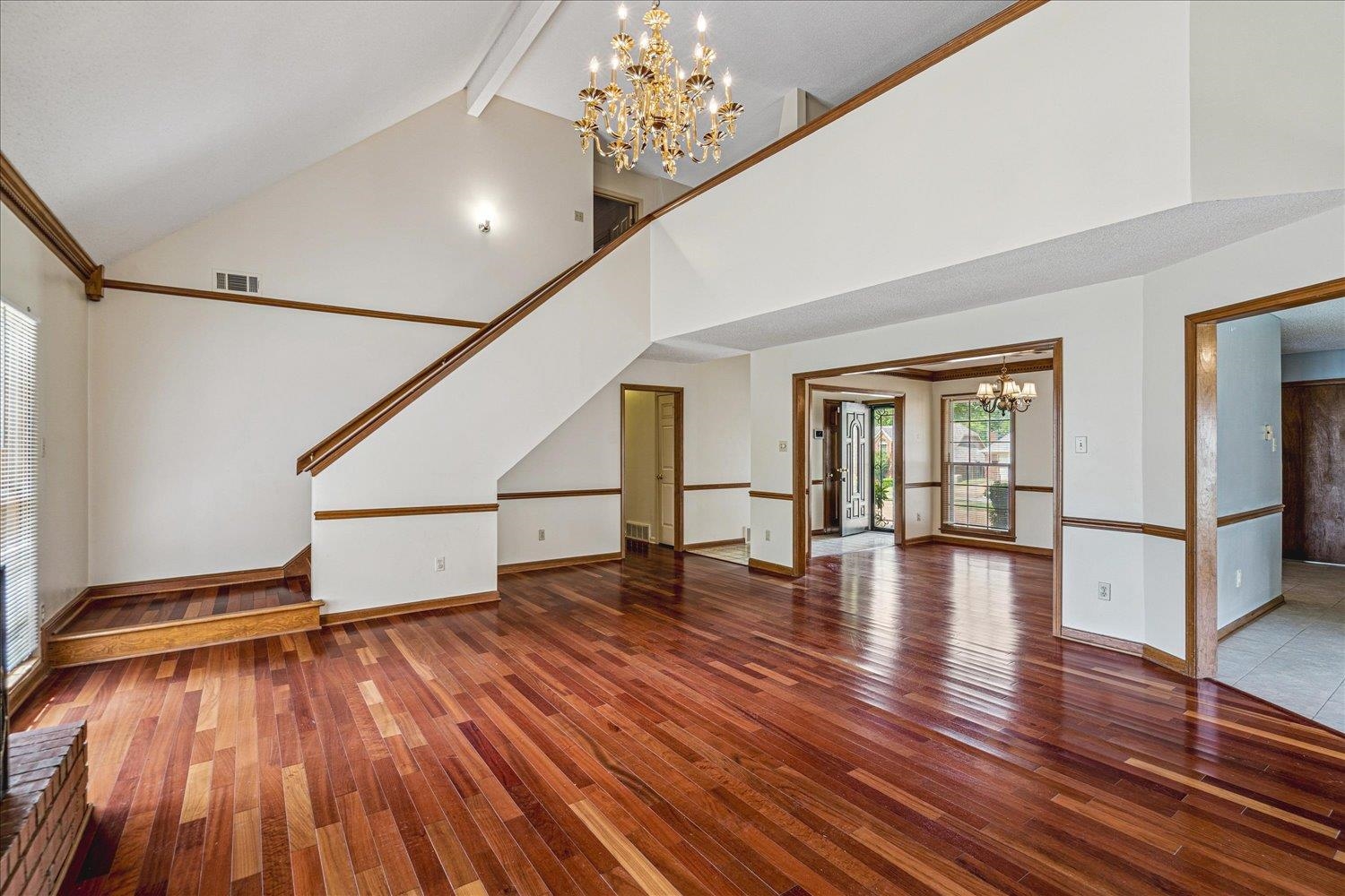 8529 Buckhurst Road Memphis, TN 38016 - Photo 11 of 36 Unfurnished living room with suspended lighting, hardwood / wood-style flooring, and vaulted ceiling