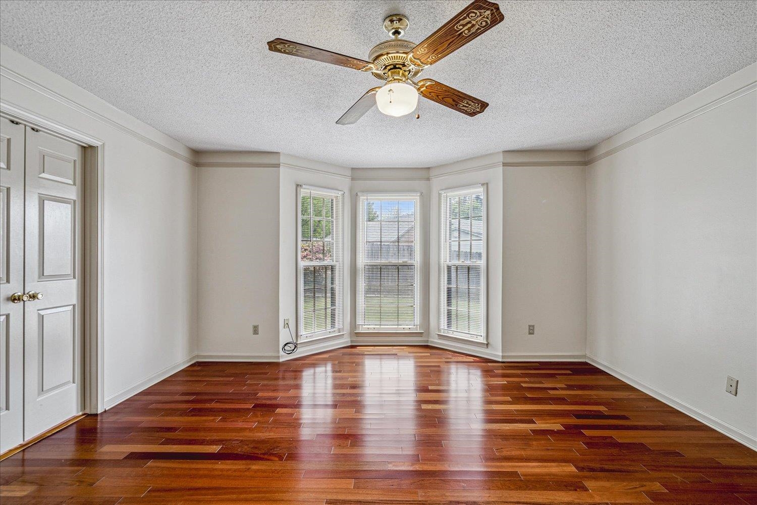 8529 Buckhurst Road Memphis, TN 38016 - Photo 19 of 36 Empty room featuring ceiling fan, dark wood-style flooring, and a textured ceiling