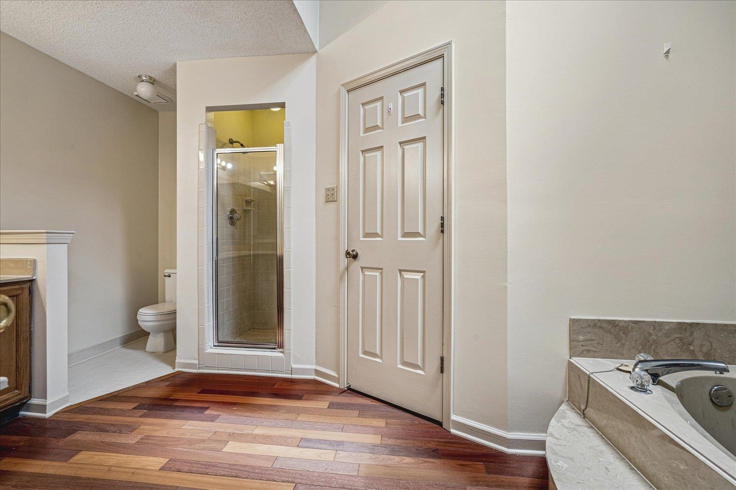 8529 Buckhurst Road Memphis, TN 38016 - Photo 23 of 36 Full bath featuring a stall shower, light wood-style floors, vanity, a garden tub, and a textured ceiling