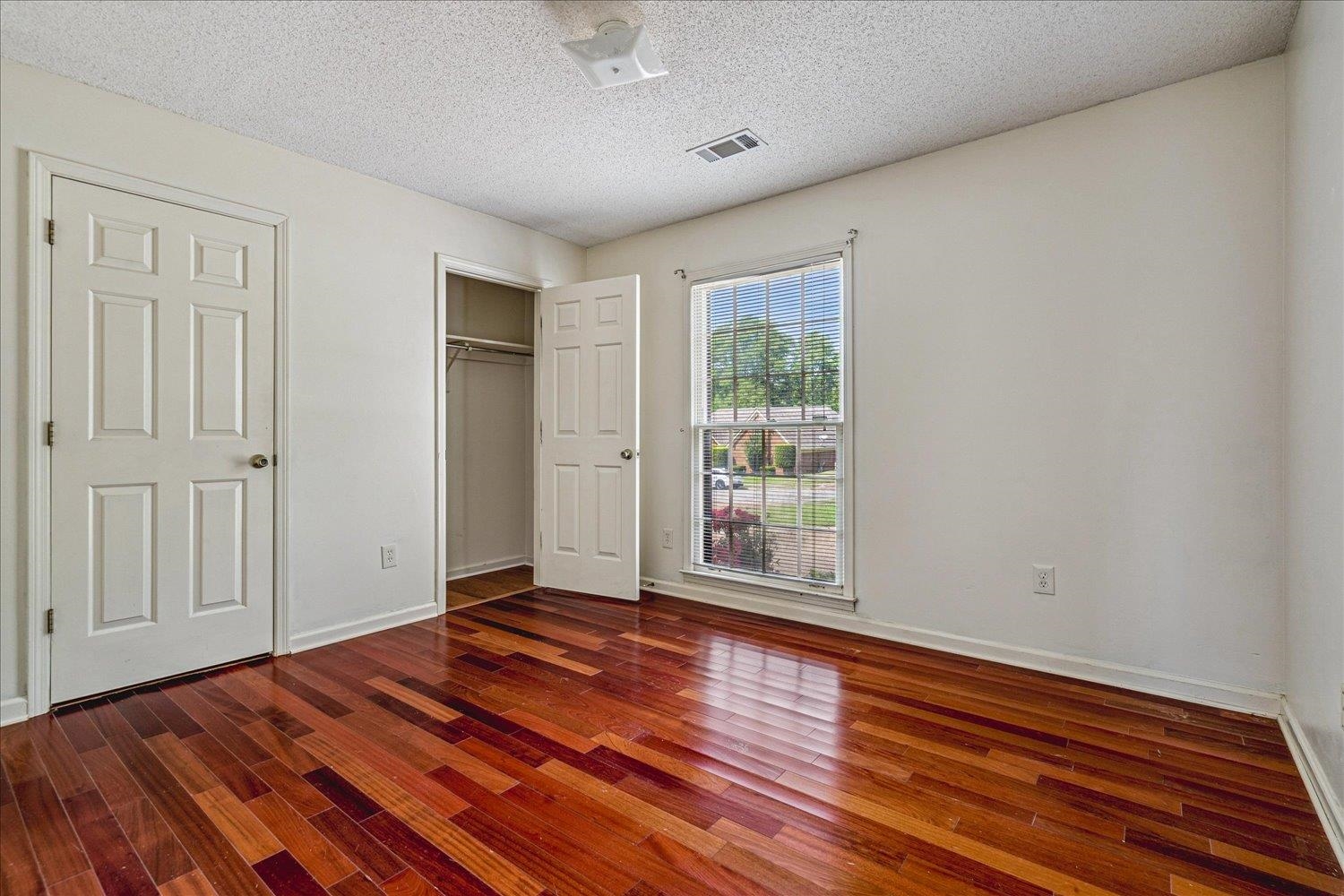 8529 Buckhurst Road Memphis, TN 38016 - Photo 24 of 36 Unfurnished bedroom with a textured ceiling, dark wood-style floors, and a closet