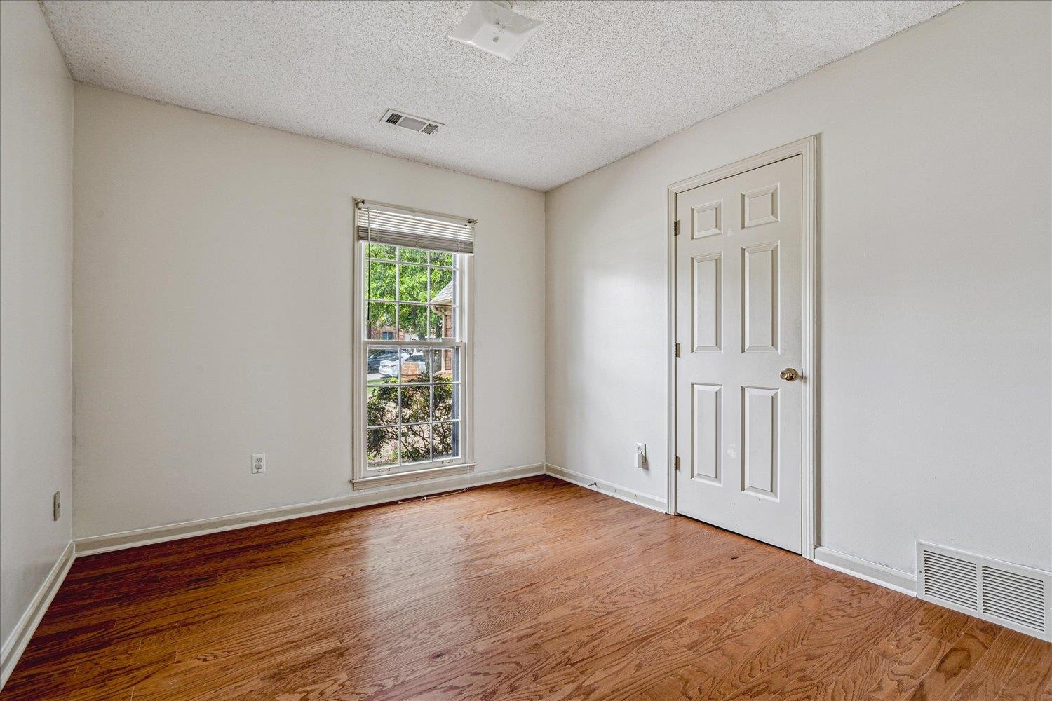 8529 Buckhurst Road Memphis, TN 38016 - Photo 25 of 36 Empty room with wood finished floors and a textured ceiling