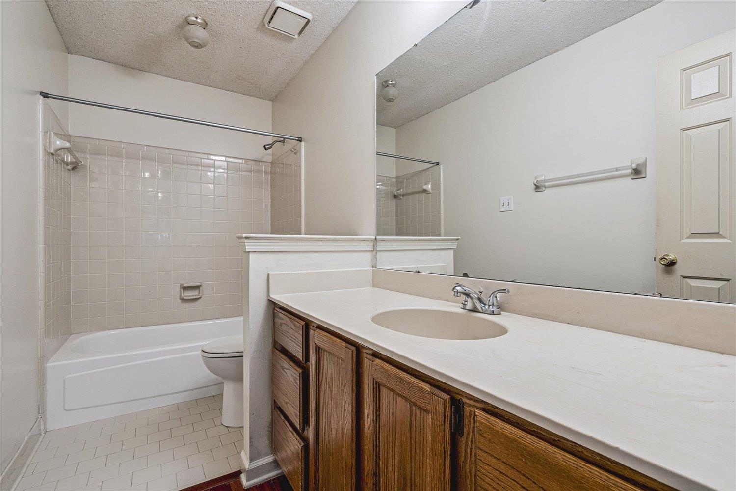 8529 Buckhurst Road Memphis, TN 38016 - Photo 26 of 36 Full bathroom featuring vanity, shower / tub combination, a textured ceiling, and dark tile patterned flooring