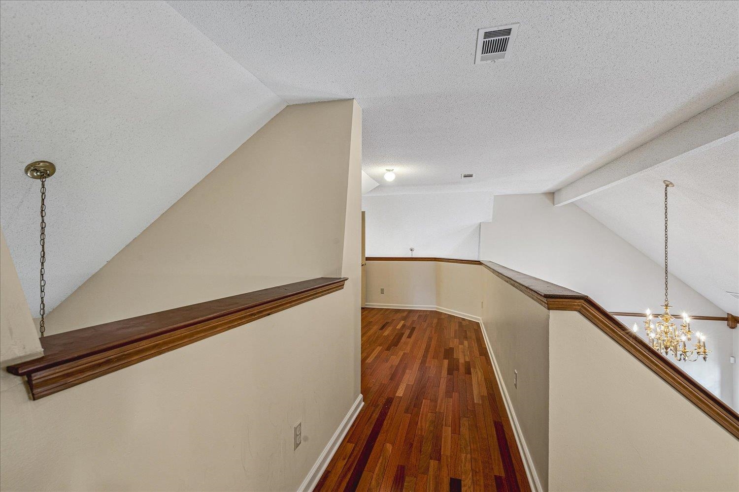 8529 Buckhurst Road Memphis, TN 38016 - Photo 27 of 36 Hallway with a chandelier, a textured ceiling, and dark wood-type flooring