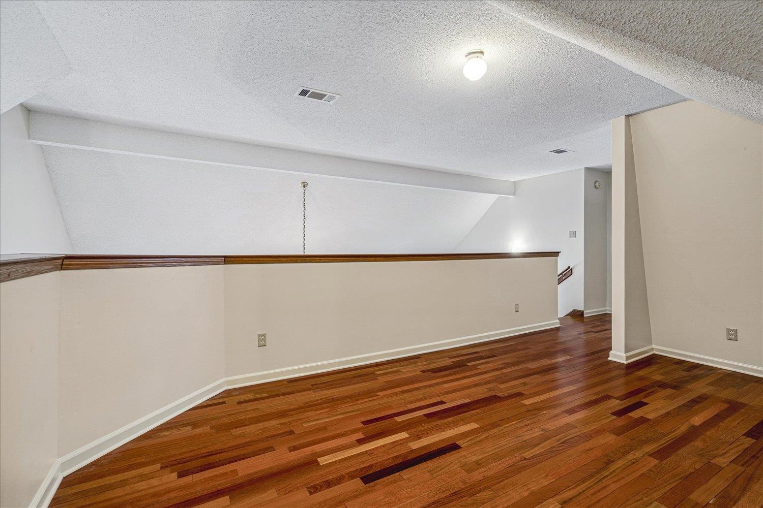 8529 Buckhurst Road Memphis, TN 38016 - Photo 28 of 36 Empty room with dark wood finished floors and baseboards