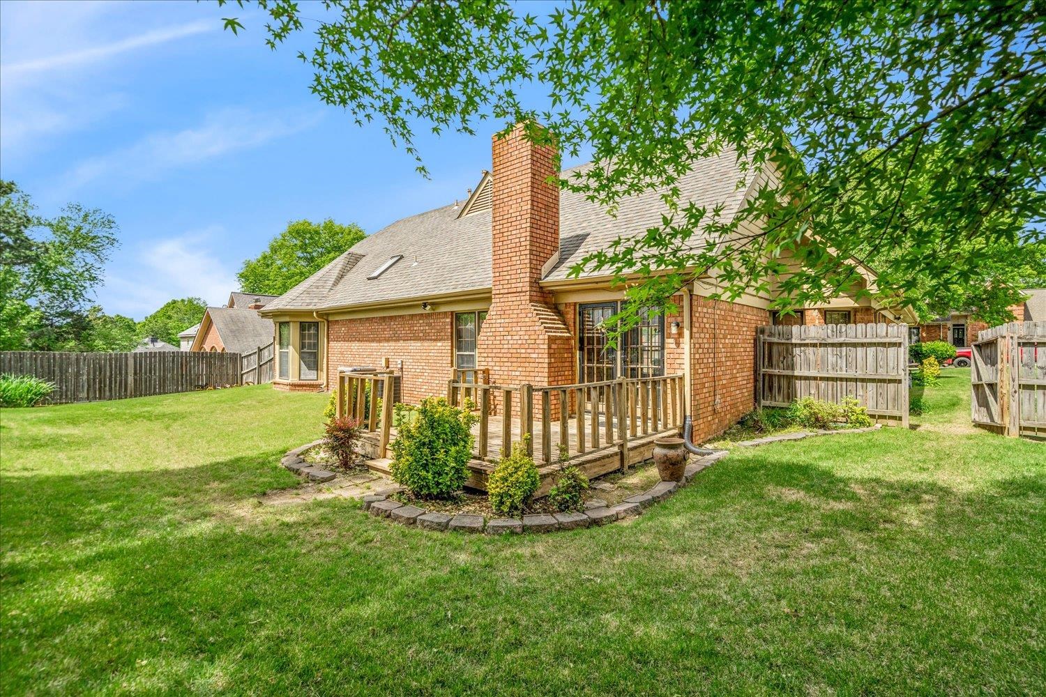 8529 Buckhurst Road Memphis, TN 38016 - Photo 33 of 36 Rear view of house featuring brick siding, a fenced backyard, a deck, and a chimney
