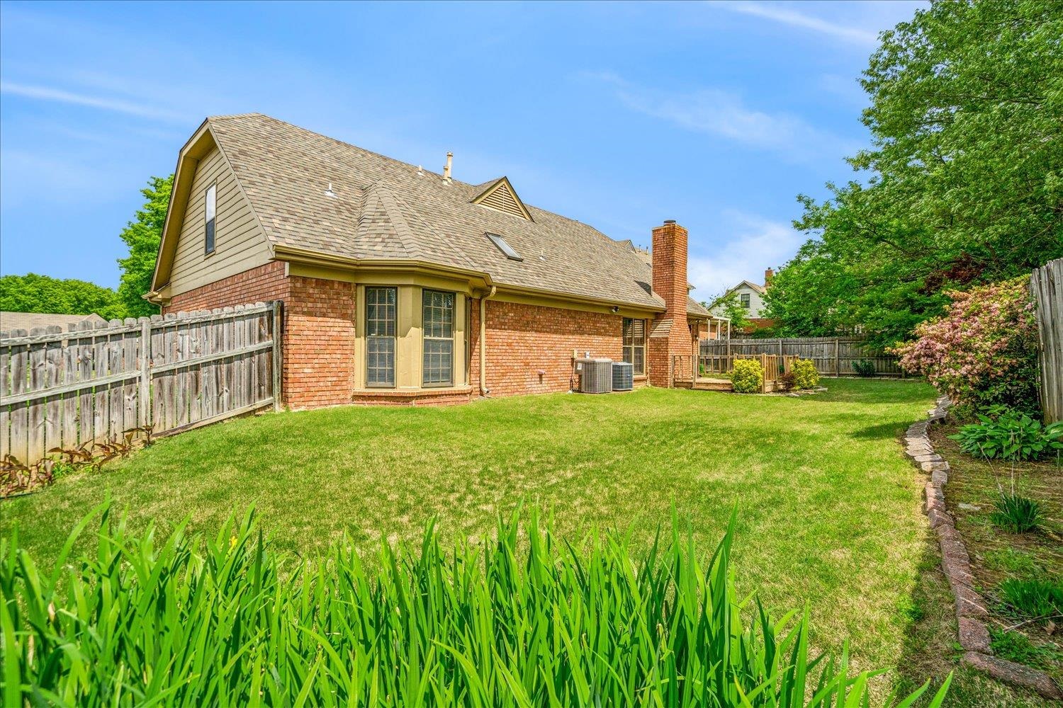 8529 Buckhurst Road Memphis, TN 38016 - Photo 36 of 36 Back of property featuring a fenced backyard, brick siding, a chimney, and roof with shingles