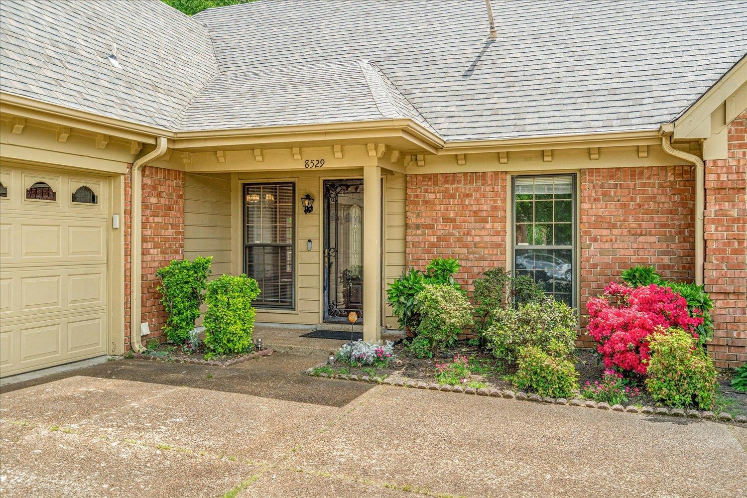 8529 Buckhurst Road Memphis, TN 38016 - Photo 4 of 36 Doorway to property featuring roof with shingles, brick siding, and a porch