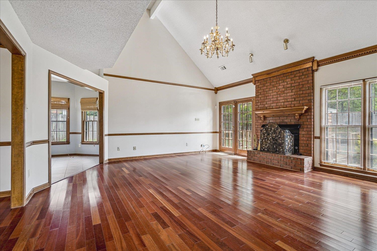 8529 Buckhurst Road Memphis, TN 38016 - Photo 8 of 36 Unfurnished living room featuring a fireplace, dark wood-style flooring, suspended lighting, and plenty of natural light