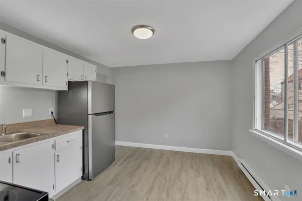 a kitchen with a refrigerator a stove a microwave and a window