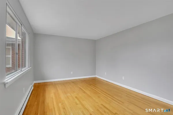 a view of a room with a wooden floor and a window