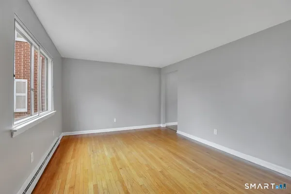 a view of room with window and wooden floor