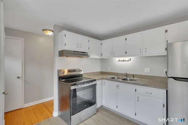 a kitchen with stainless steel appliances granite countertop a sink stove and cabinets