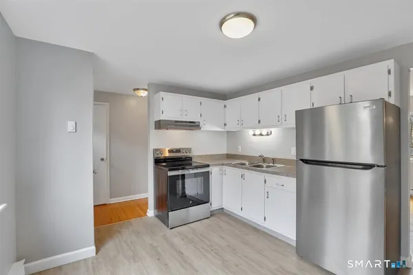 a kitchen with stainless steel appliances a refrigerator sink and cabinets