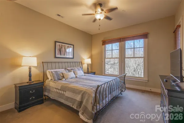 a bedroom with a bed chandelier and a window