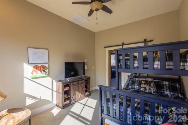 a living room with furniture a flat screen tv and a book shelf
