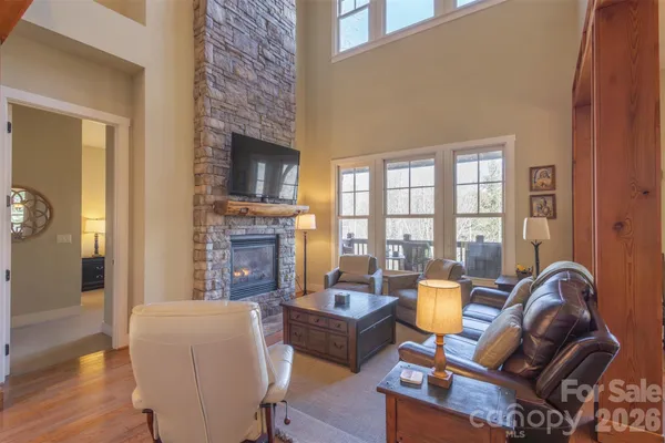 a living room with furniture a fireplace and a floor to ceiling window
