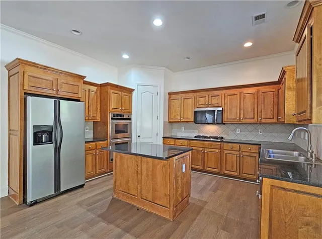 a kitchen with stainless steel appliances granite countertop a refrigerator and a sink