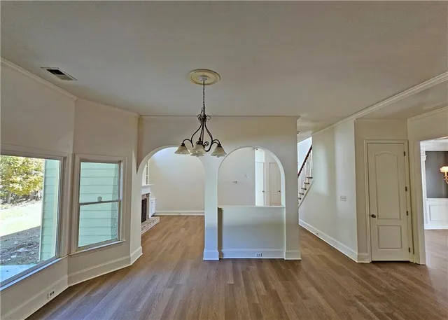 a view of empty room with wooden floor
