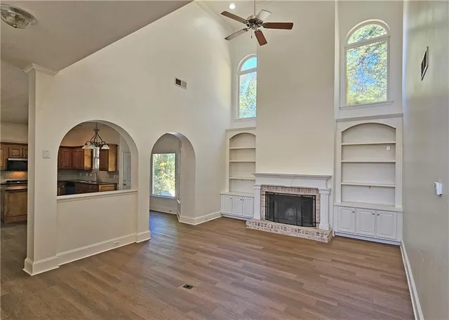 a view of empty room with a fireplace and wooden floor