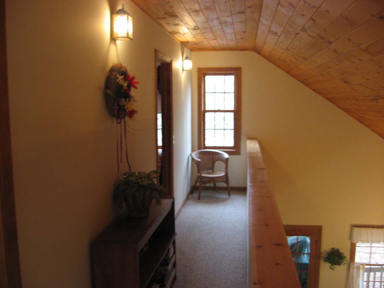 219 Slope Road Tolland, MA 01034 - Photo 16 of 21 a hallway with a couch and a potted plant next to a window