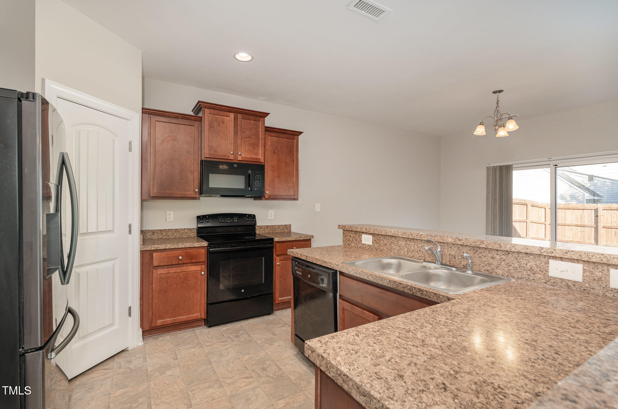 3529 Eastern Branch Road Raleigh, NC 27610 - Photo 10 of 29 a kitchen with stainless steel appliances granite countertop a stove a refrigerator and a sink with wooden cabinets
