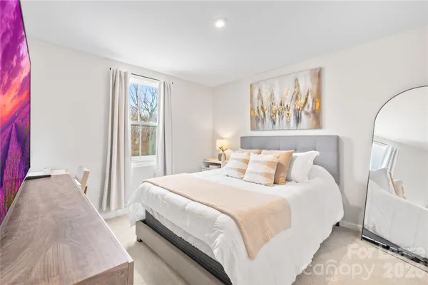 a bedroom with a bed and a large mirror