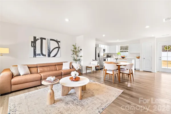 a living room with furniture a rug and a table